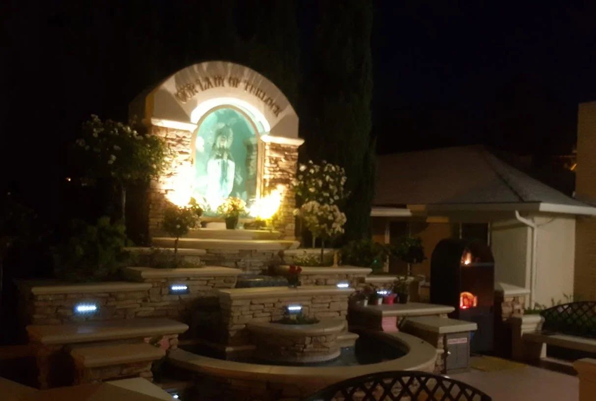 The Marian grotto at St. Thomas lit at night